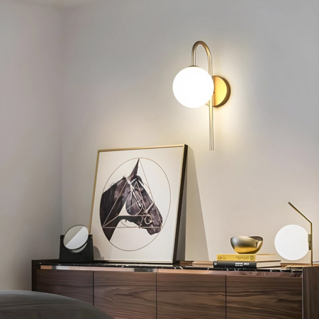 Aplique dorado colgado sobre un aparador junto a un cuadro de un caballo