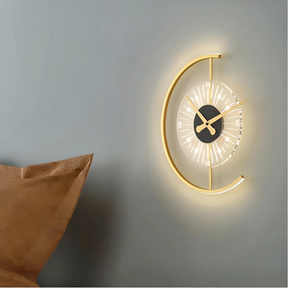 Aplique dorado con reloj colgado en una pared gris junto a un cojín