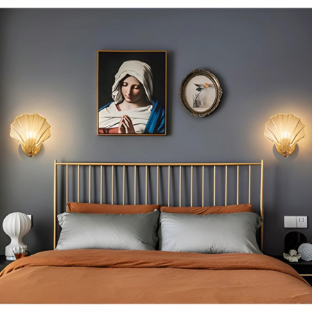 Dos apliques de concha colgados junto a un marco de fotos en un dormitorio