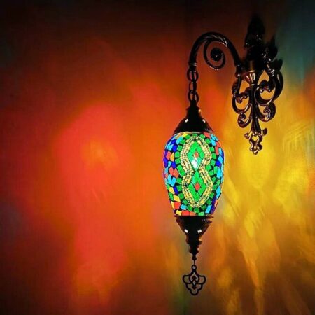 en una pared vemos un aplique atornillado en ella es de hierro y estilo mosaico oriental multicolor
