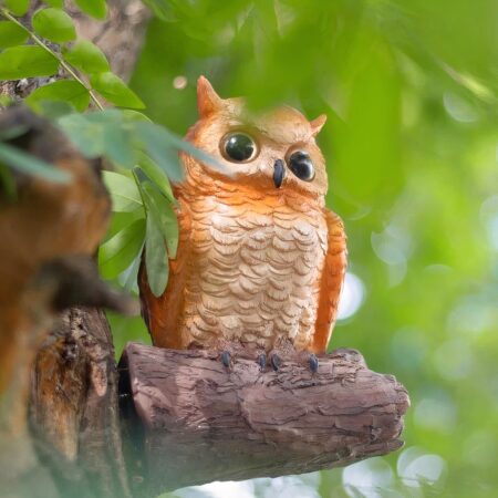 una lámpara de pared con forma de búho realista se puede ver en un árbol