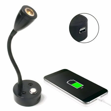 Aplique negro con base redonda, tallo flexible y cabezal luminoso. A la derecha, un teléfono con un cable blanco enchufado y un símbolo de batería medio verde en la pantalla. Arriba, una burbuja con un primer plano de un puerto USB en la base negra. Todo sobre fondo blanco.