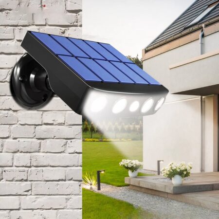 Aplique solar de amplio espectro con detector de movimiento montado en la pared de un jardín para iluminar el camino.